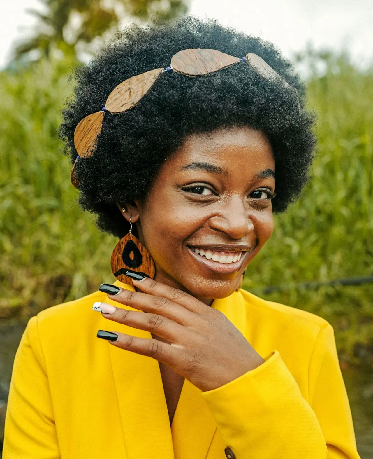 a woman wearing a yellow jacket and a pair of earrings